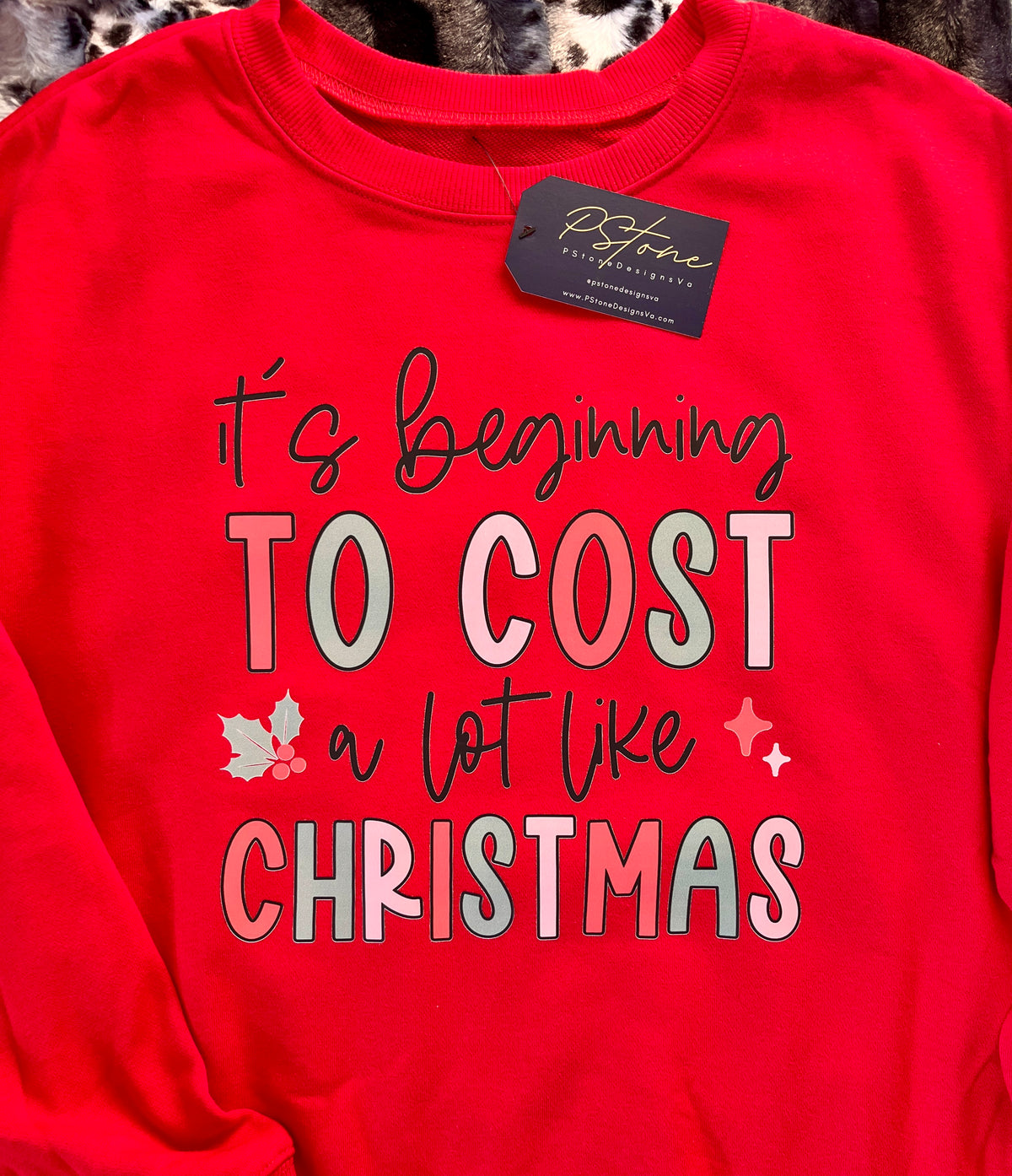 A red sweatshirt with text 'It's beginning to cost a lot like Christmas' printed on the front.