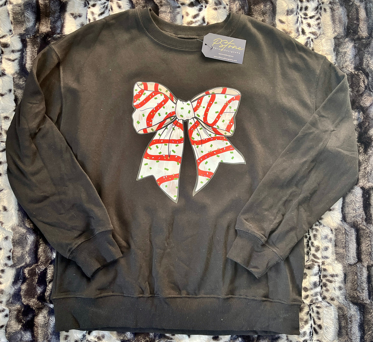 A black sweatshirt with a red and white bow design on the front.