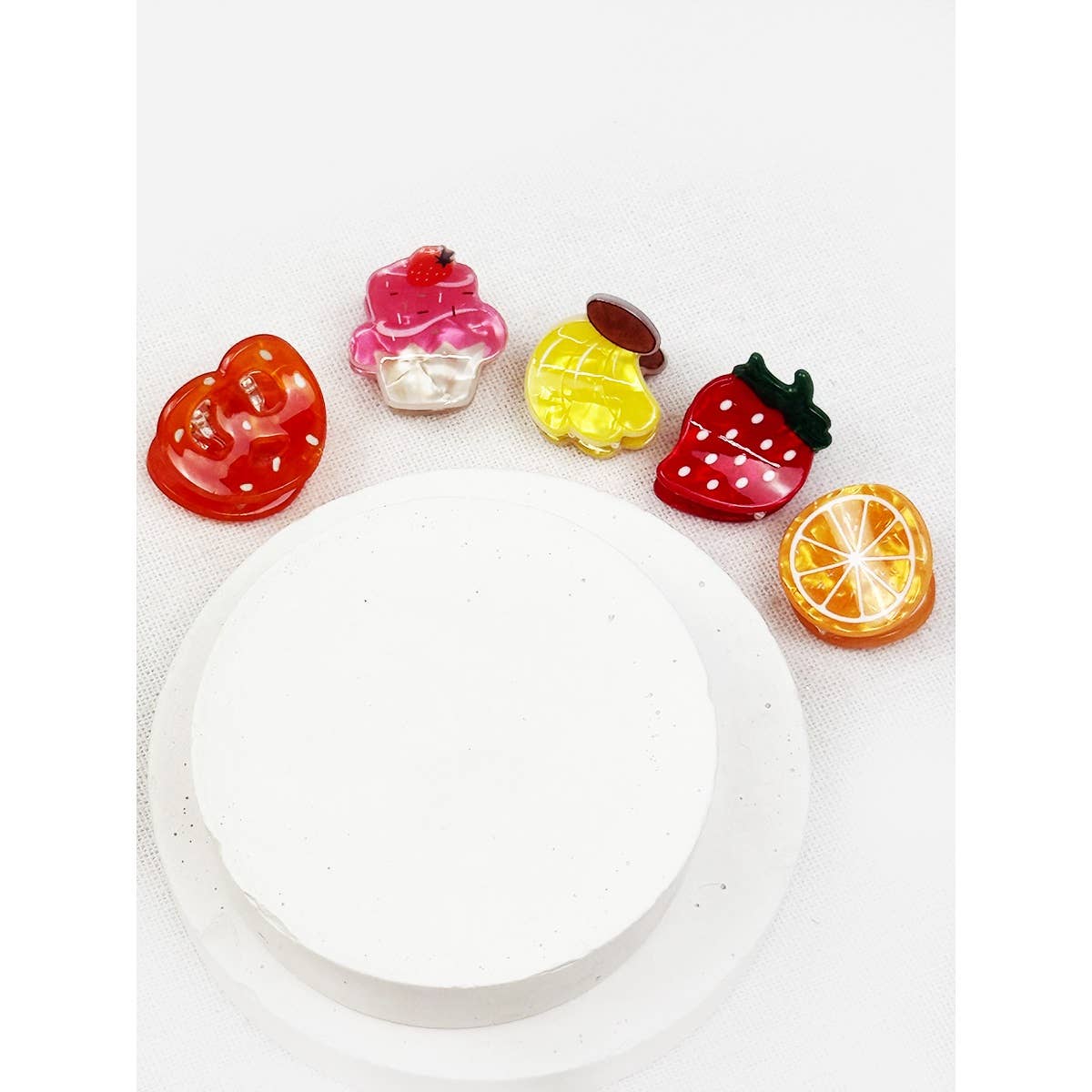 Colorful fruit-shaped hair clips on a white background