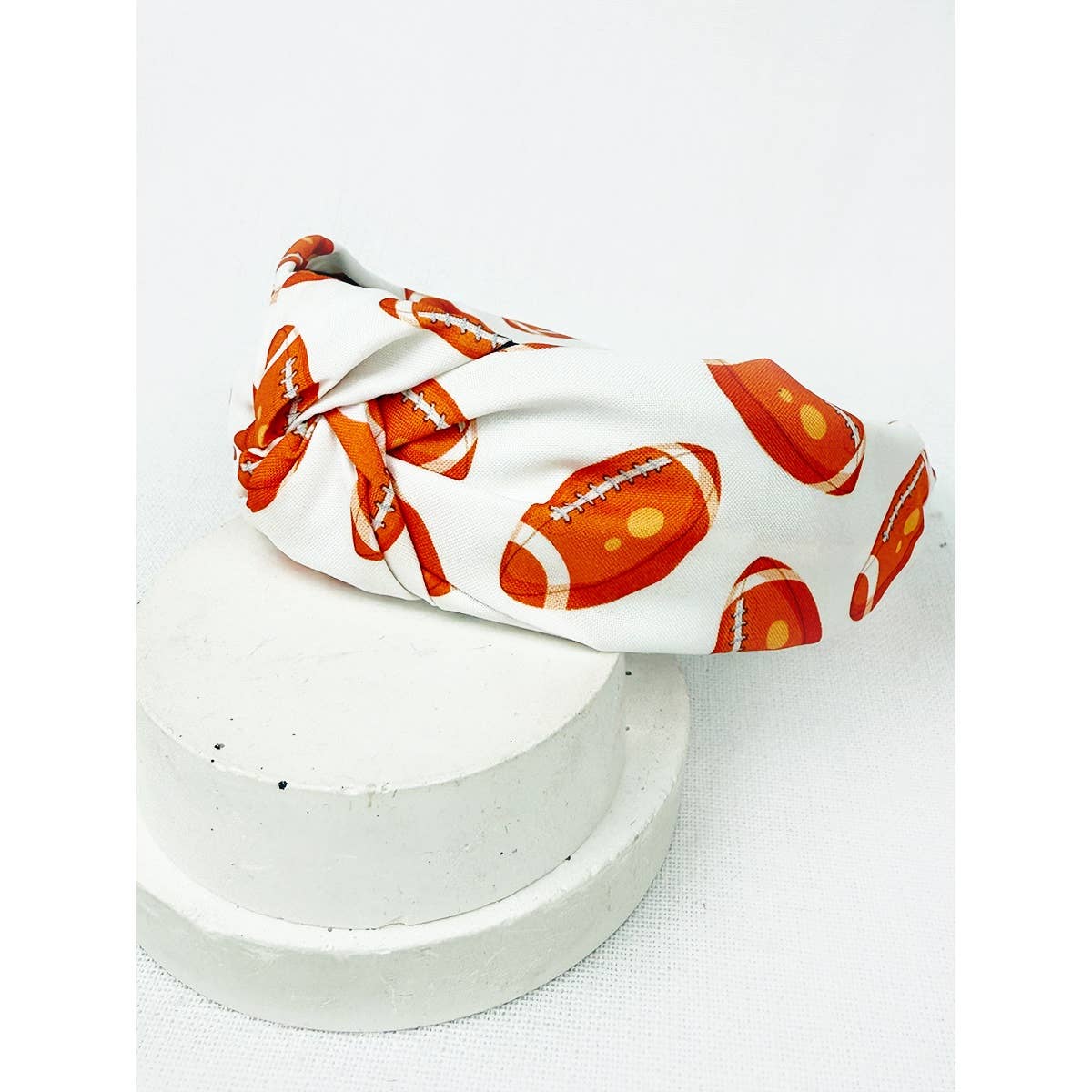 White headband with orange football pattern on a white background