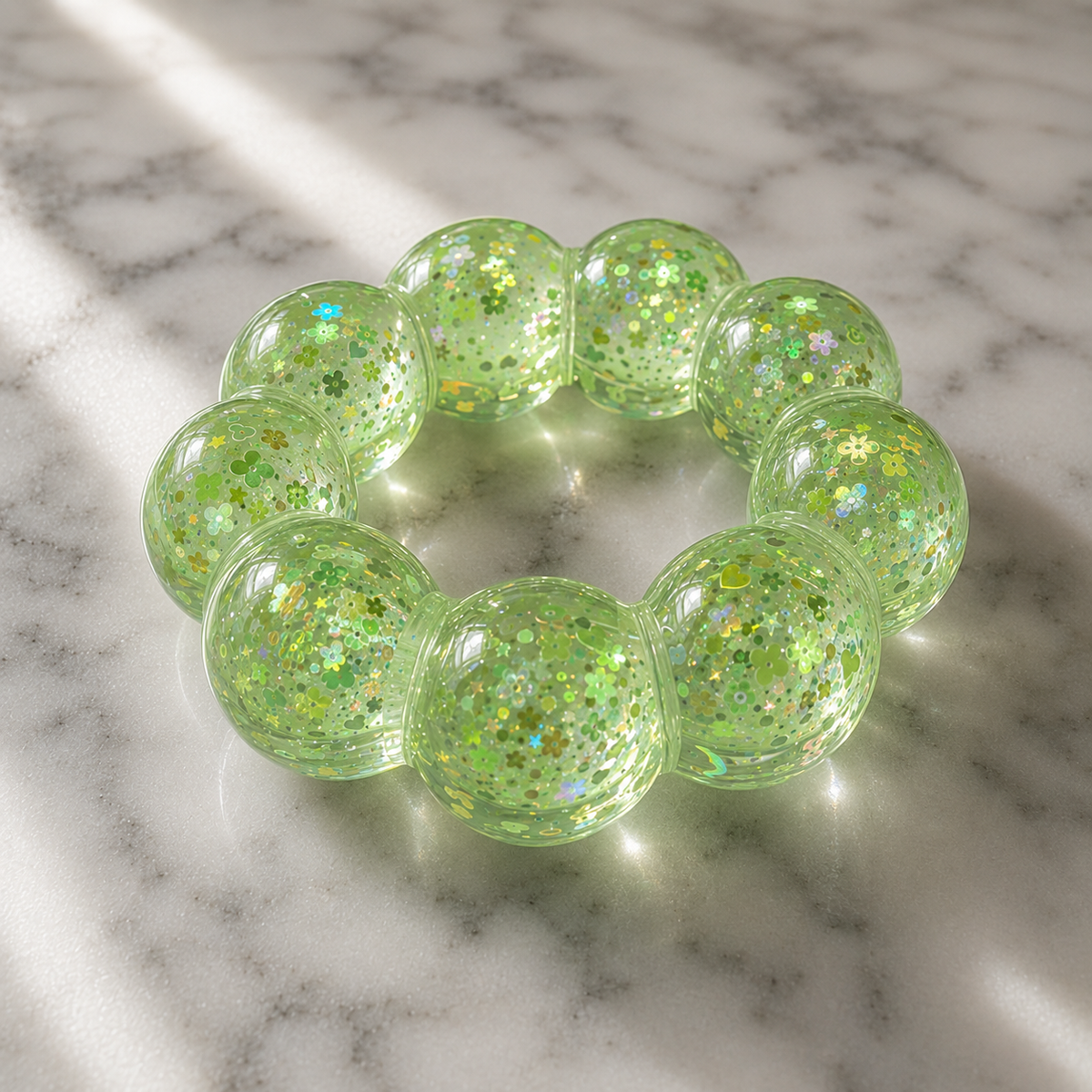 Lime green glittery squishy bracelet on a marble surface