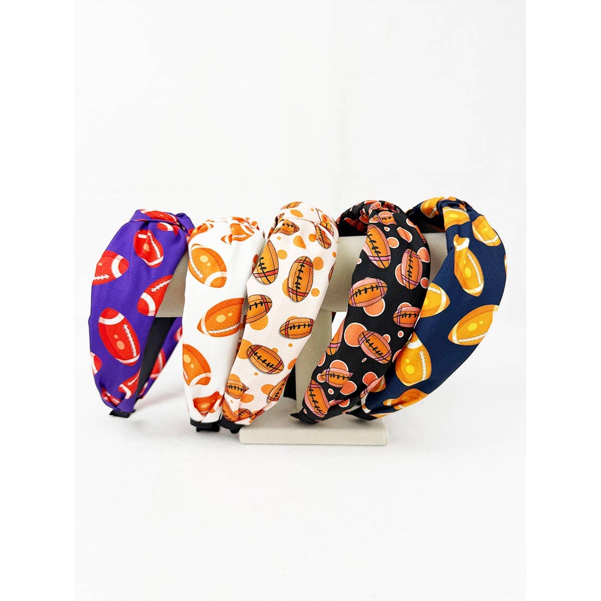 Set of four colorful headbands with football patterns on a white background
