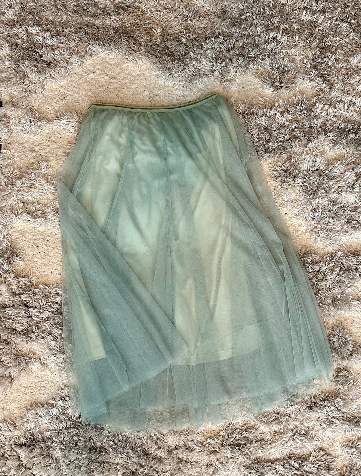 Light green tulle skirt on a textured surface
