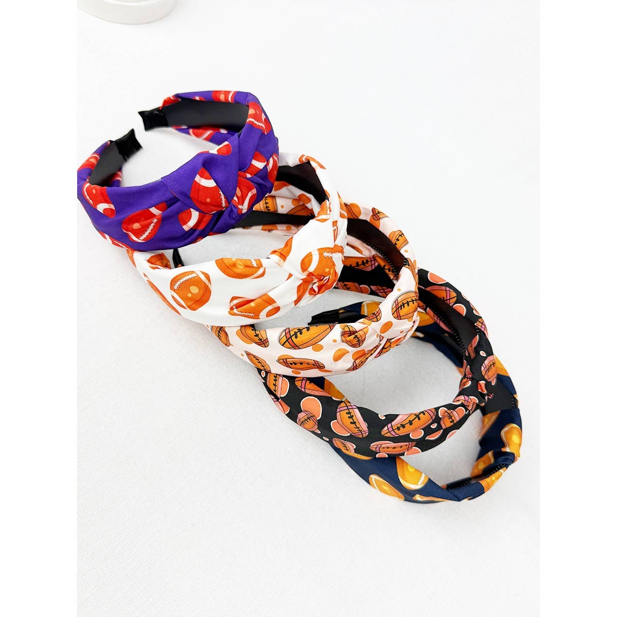 Three colorful headbands with football themed designs on a white background