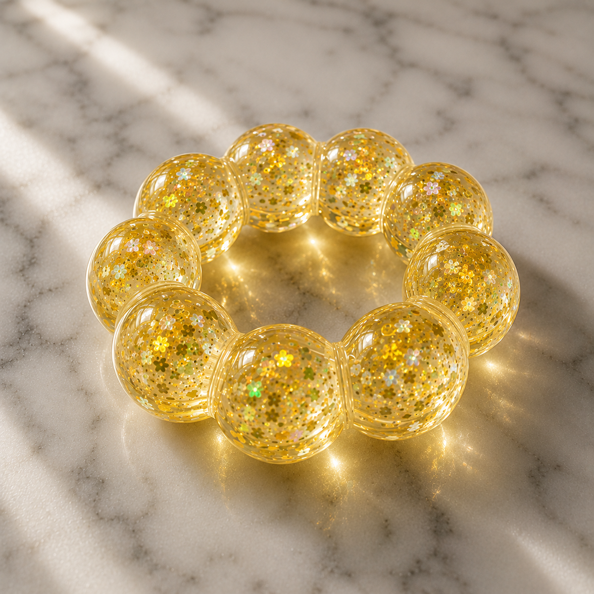 Gold glittery squishy bracelet on a marble surface