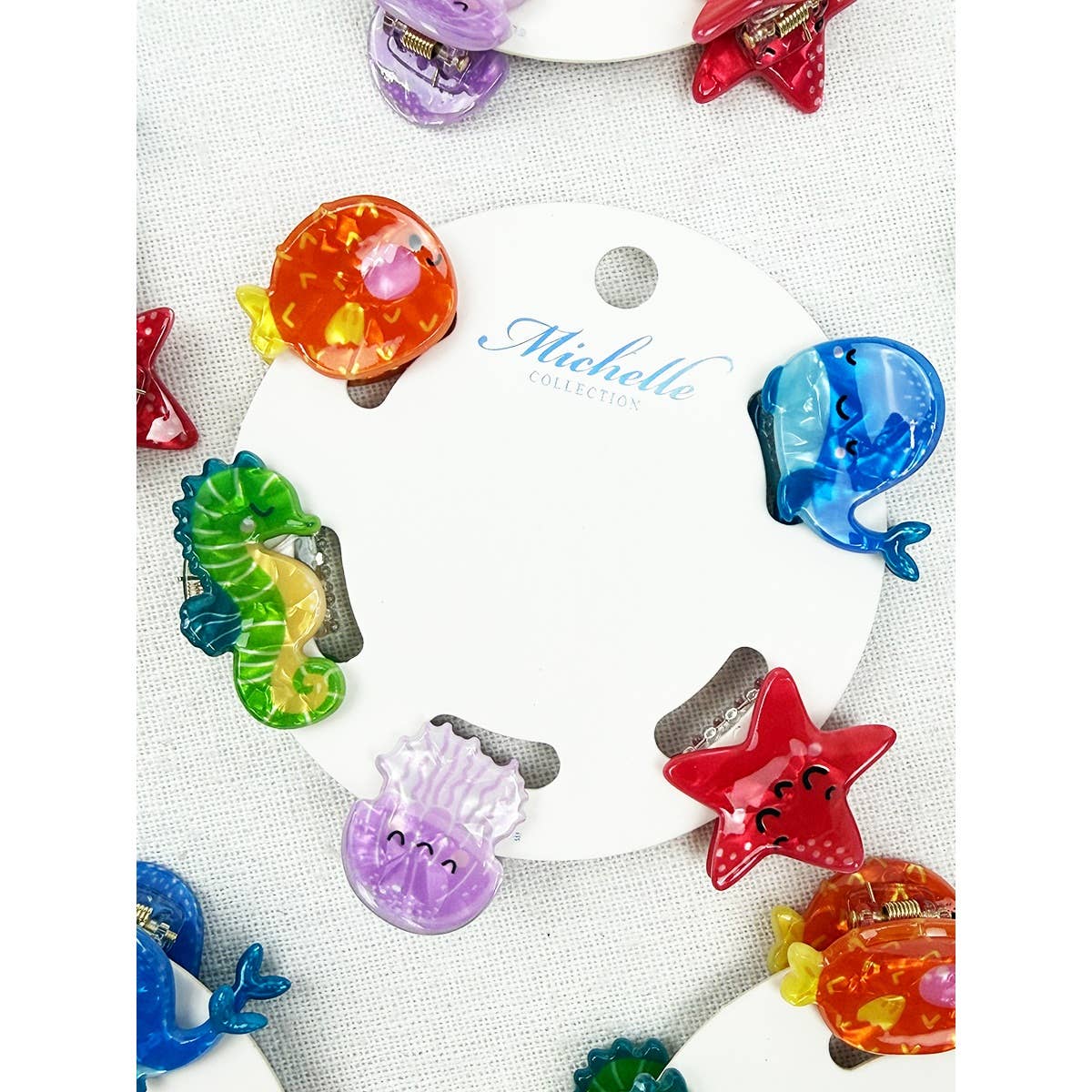 Colorful sea-themed hair clips on a branded display card with 'Michelle' collection name.