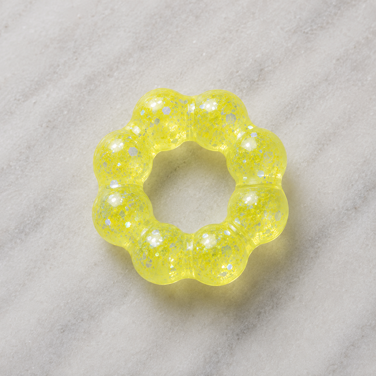 Yellow squishy bracelet on a marble surface