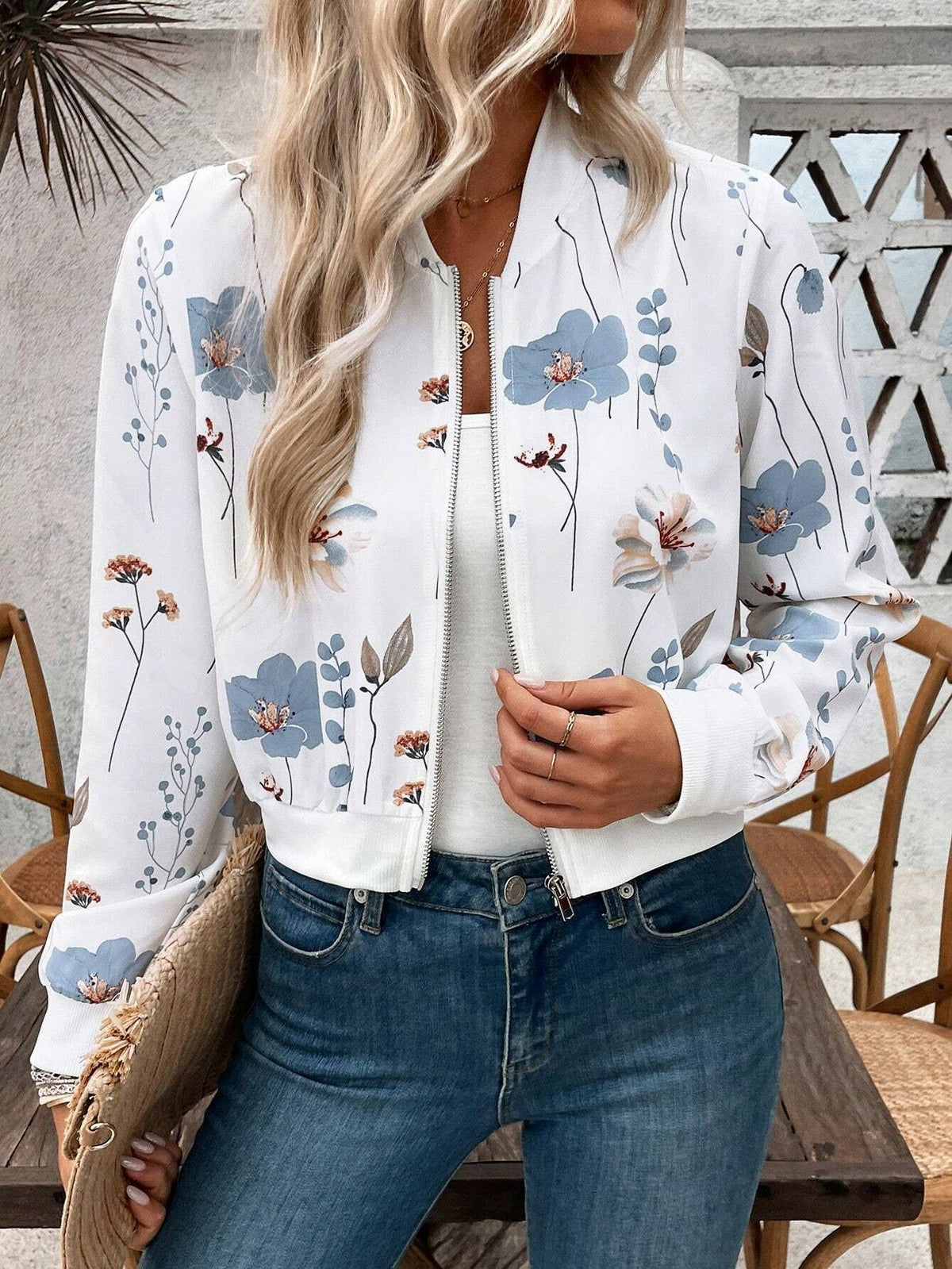Person wearing a floral bomber jacket in an outdoor setting