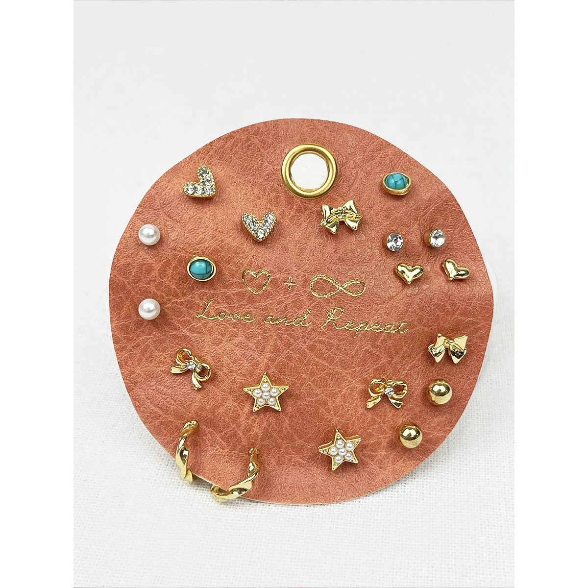 Round jewelry holder with various earrings on a white background