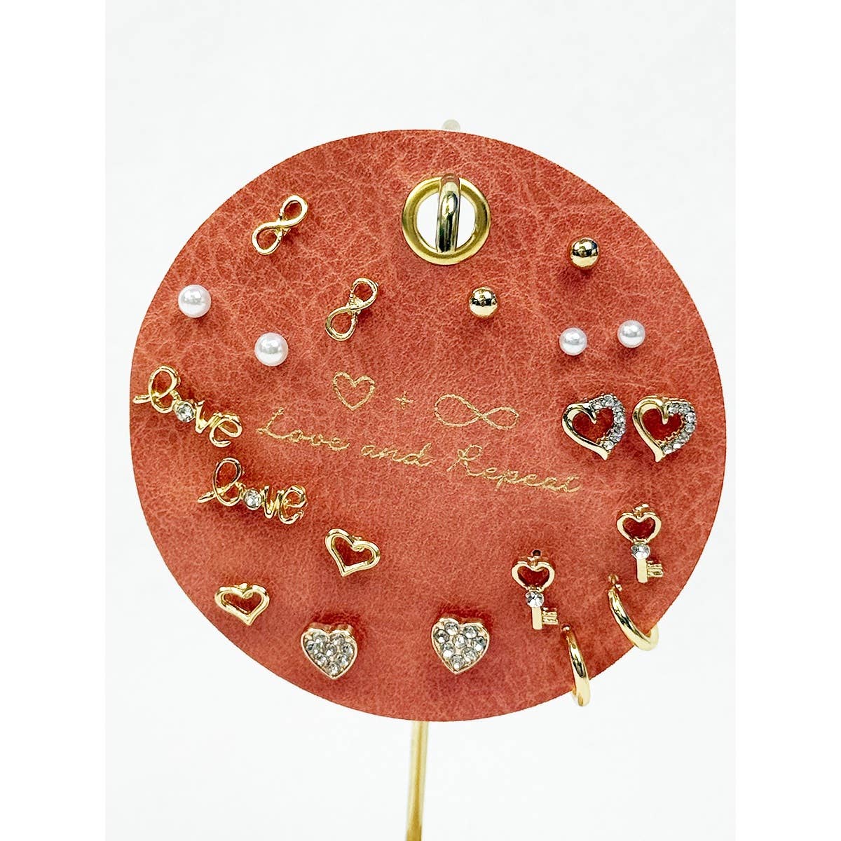 Round jewelry display with various earrings on a red background