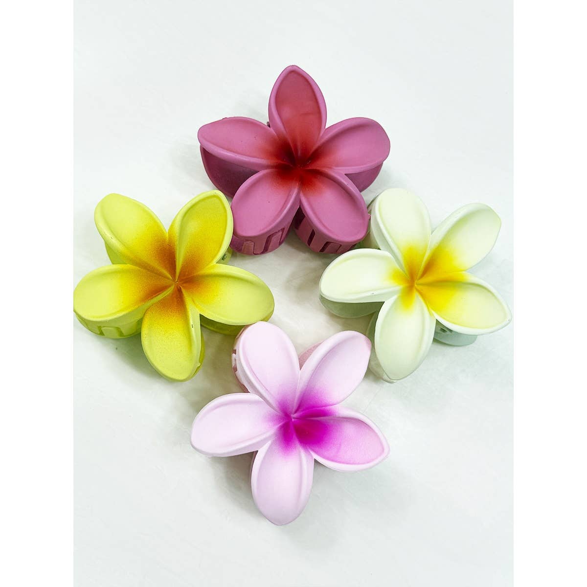 Four colorful flower-shaped hair clips on a white background