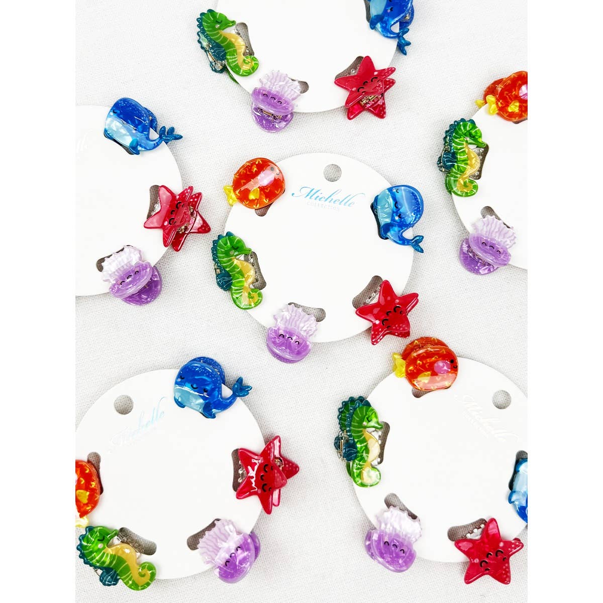 Colorful fish-shaped hair clips on a white card with 'Nadella' branding.