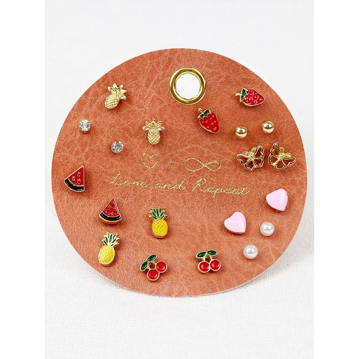 Round jewelry display with various earrings on a white background