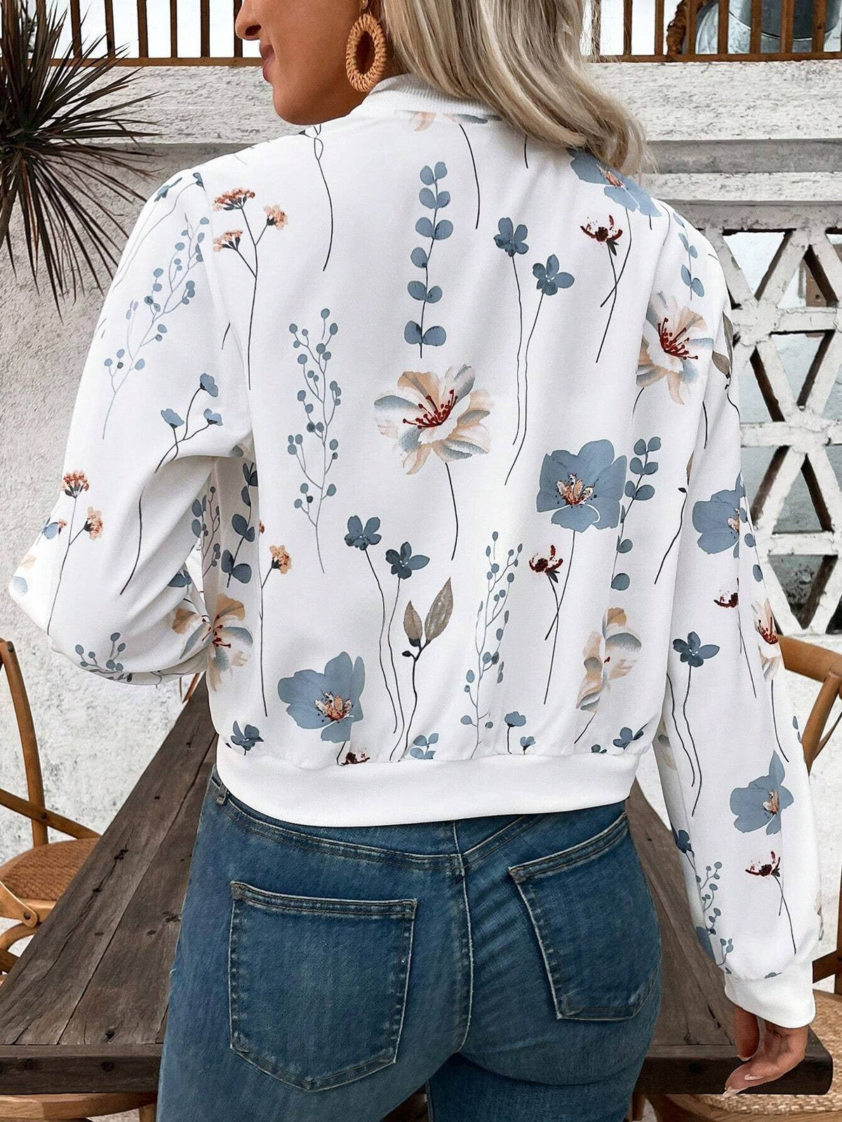 Person wearing a floral blouse with a white background