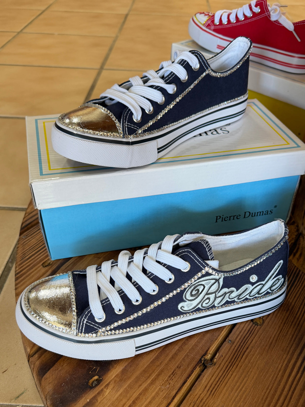 Navy and white sneaker with 'Bride' text painted on, with added rhinestones.