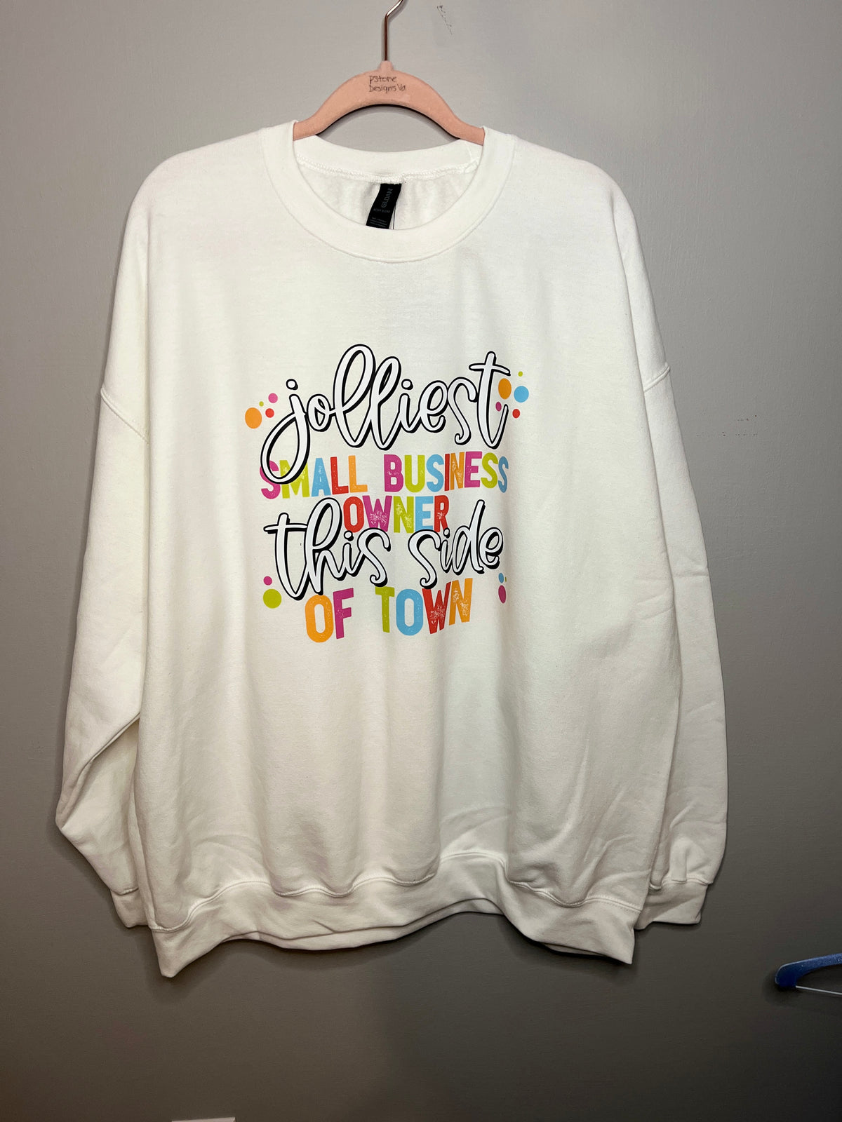 white sweathshirt that reads 'jolliest small business owner this side of town'