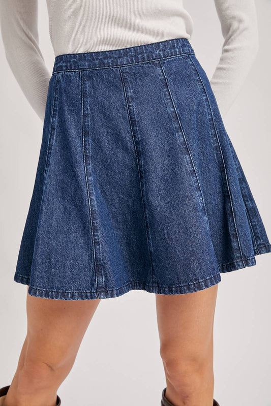Blue denim skirt worn by a person on a plain background