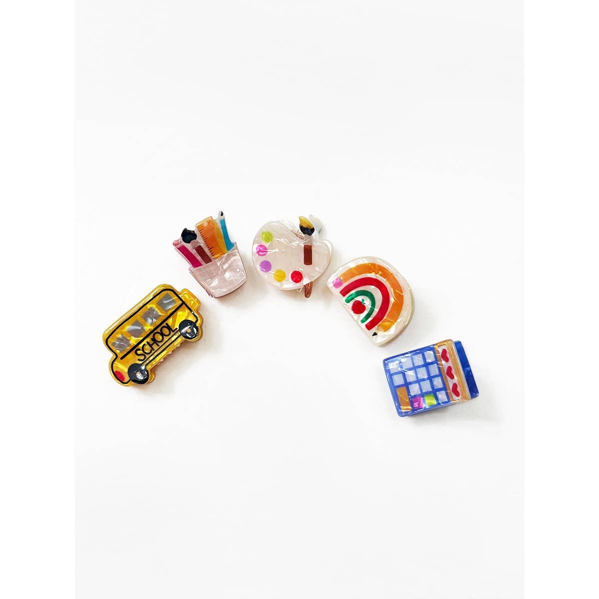 Set of colorful school themed hair clips on a white background