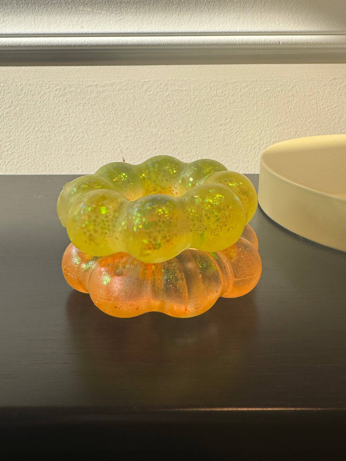 Two squish bracelets in yellow and orange on a dark surface.