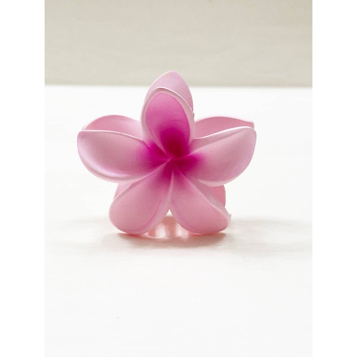 Pink flower-shaped object on a white background