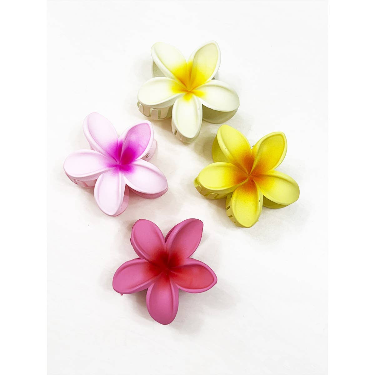 Four colorful flower-shaped hair clips on a white background