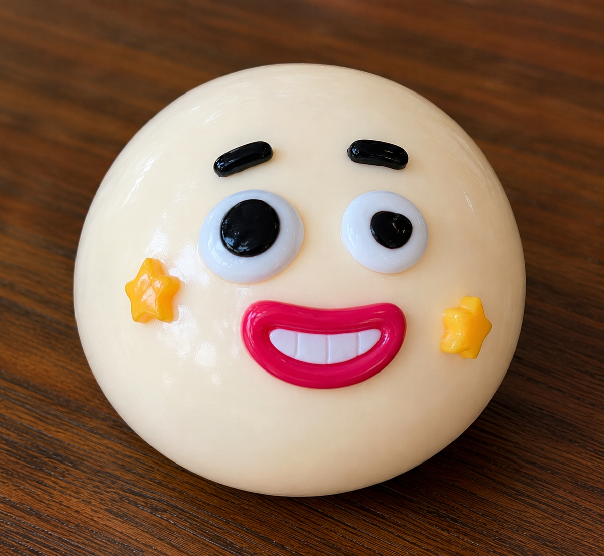 Round white squish ball with a face design on a wooden surface