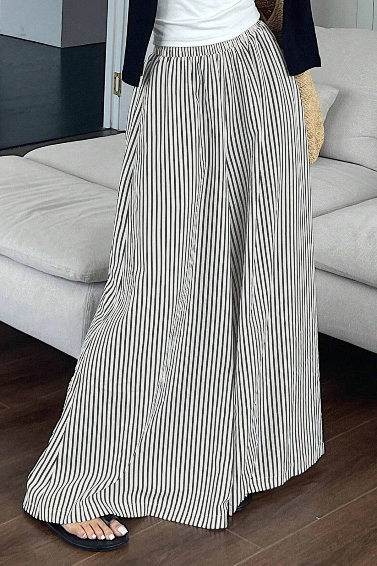 Person wearing a long black and white striped skirt in a living room setting.