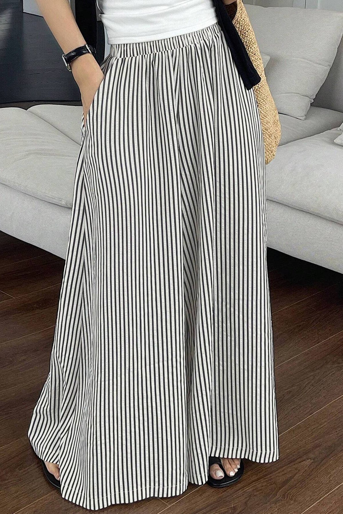 Person wearing a long black and white striped skirt in a living room setting.