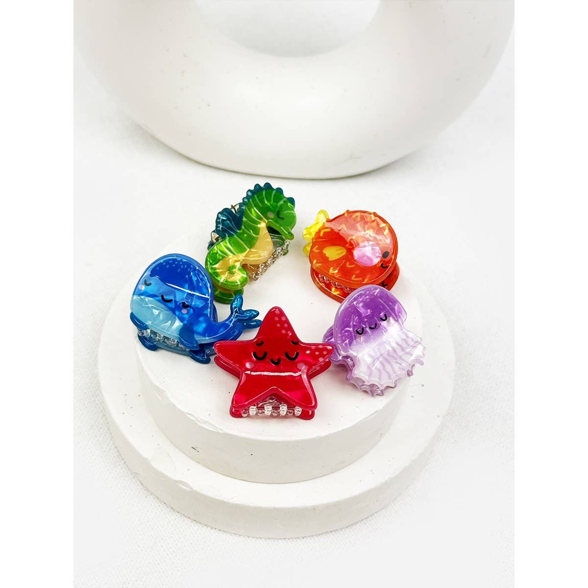Colorful sea animal-shaped hair clips on a white surface