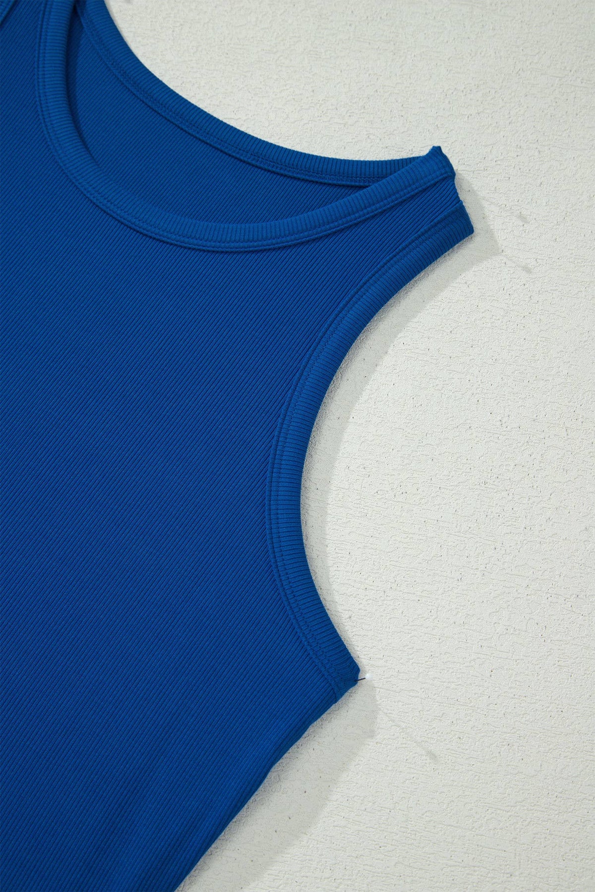 Blue tank top on a textured white surface