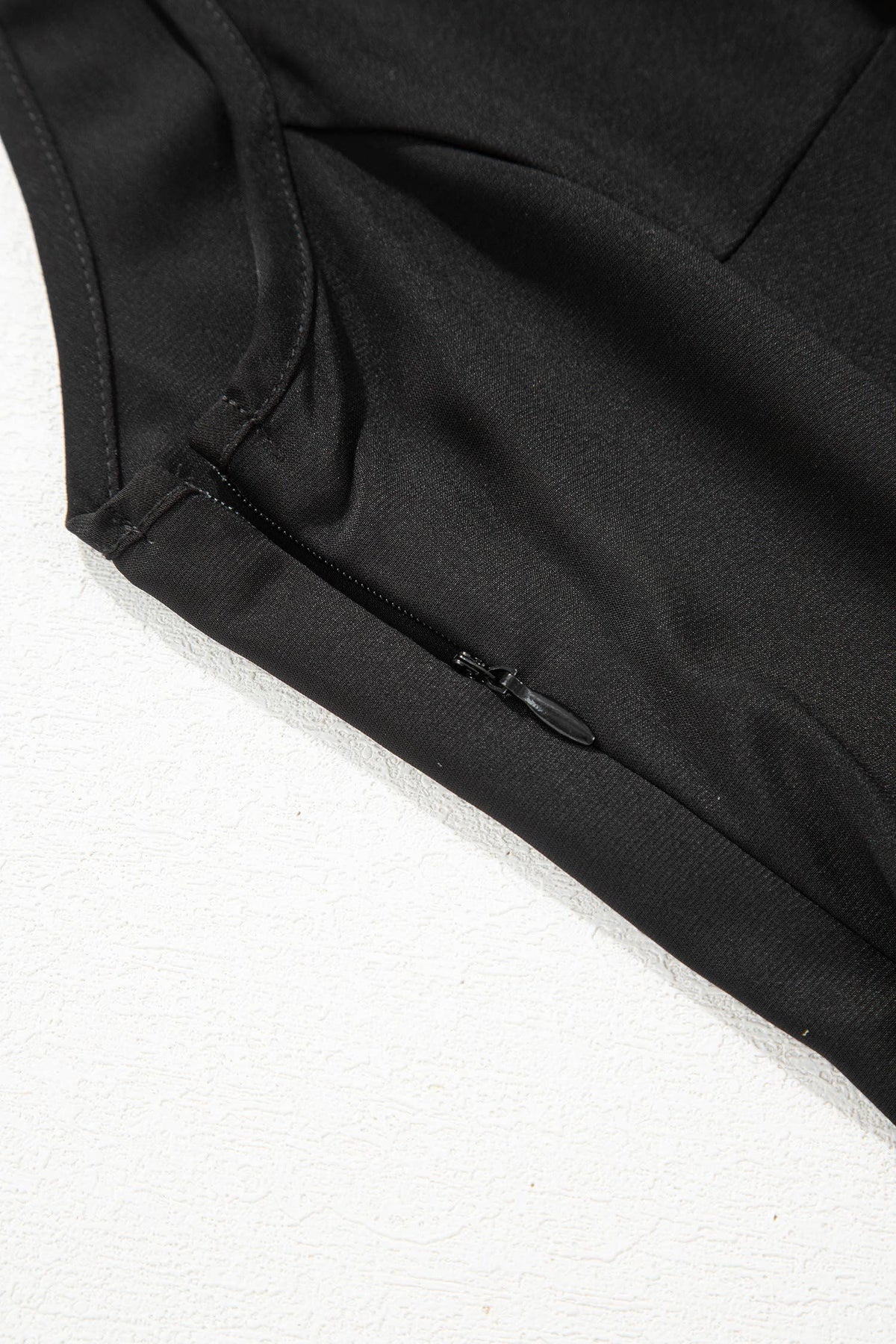 Close-up of a black garment with a zipper on a white background