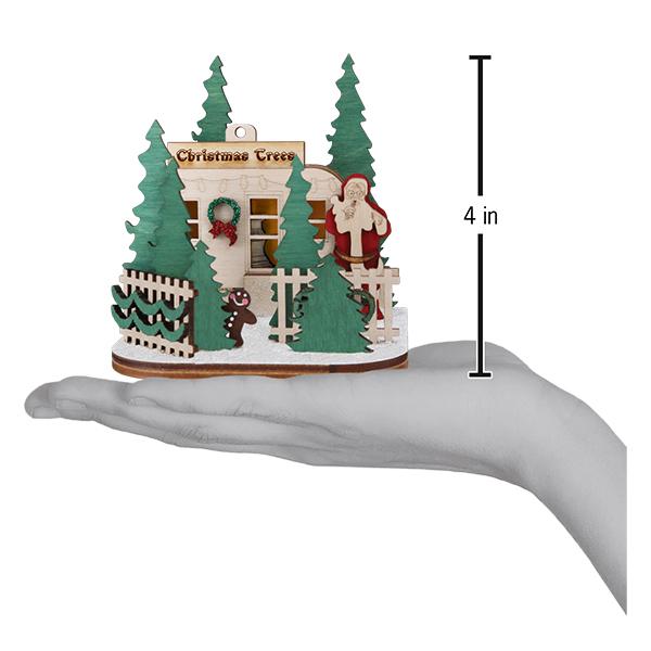 Chrismas tree lot ornamnet with  christmas tree, gingerbread man, Santa, and fence wooden figures in the palm of a hand. The ornament measures 4 inches tall. 