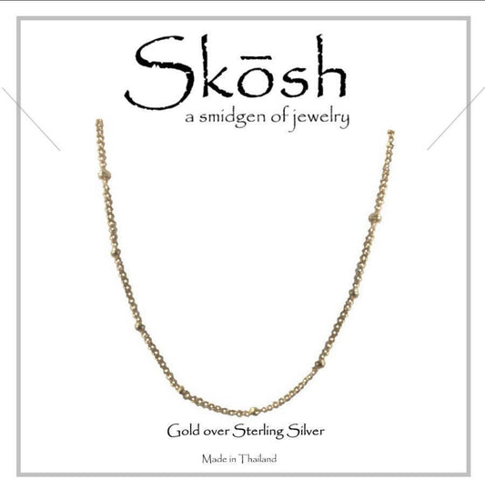 A 20-inch gold-colored necklace with a textured chain design, presented against a white background with the brand name 'Skosh' prominently displayed at the top.